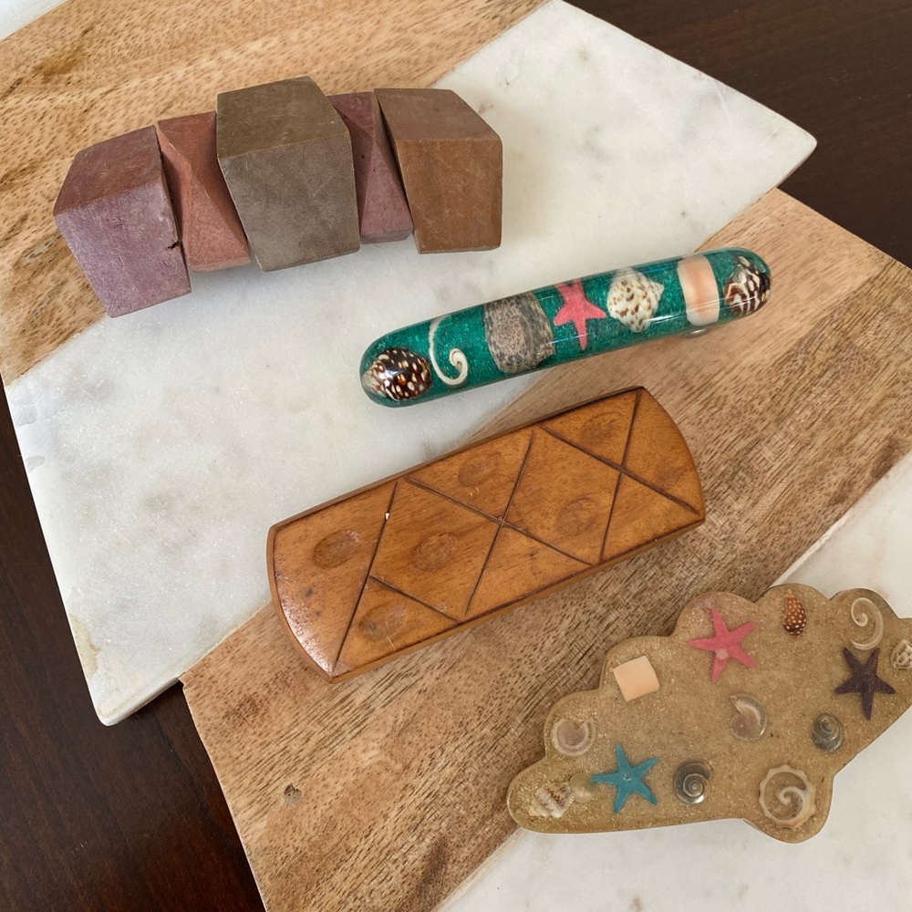 All four (4) hair accessories/clips made of shells and wood